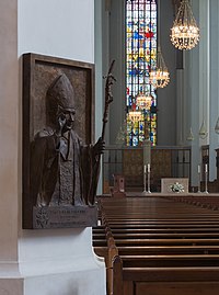 L'intérieur de la Frauenkirche de Munich, en Bavière : à l'arrière-plan, le chœur de la cathédrale ; au premier plan, dans la nef, un bas-relief représentant le pape Benoît XVI, archevêque de Munich et Freising de 1977 à 1982. (définition réelle 3 044 × 4 100)